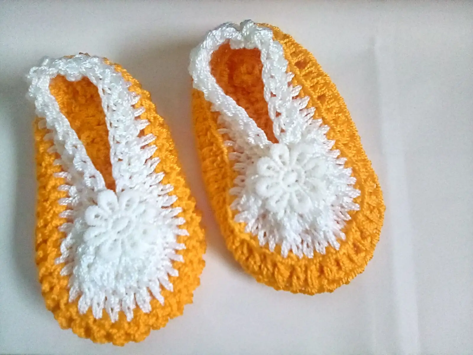 Zapatitos tejidos  a crochet, elaborados con hilo en tonos mostaza y blanco, - Imagen 3