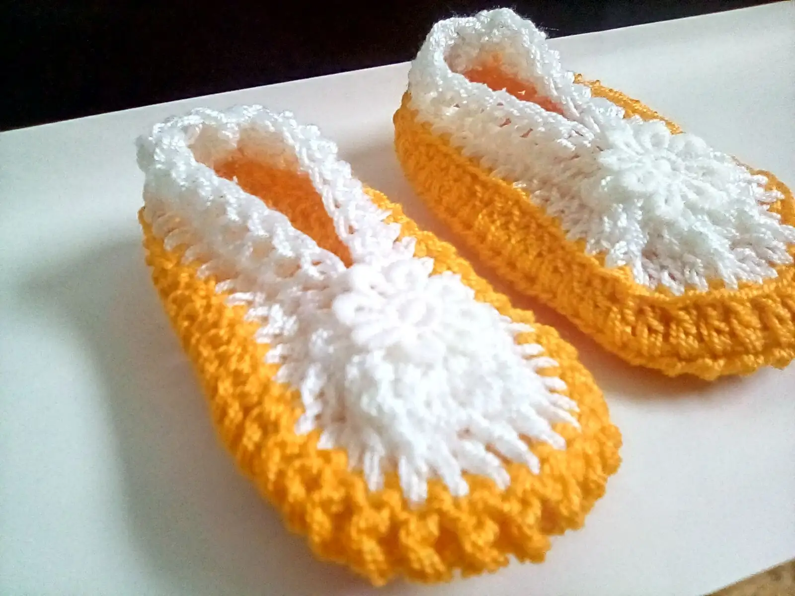 Zapatitos tejidos  a crochet, elaborados con hilo en tonos mostaza y blanco, - Imagen 2